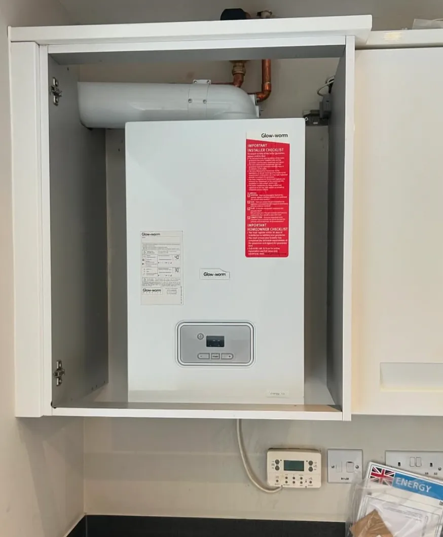 Glow-worm boiler installed neatly inside a kitchen cupboard by Infinite Plumbing & Heating