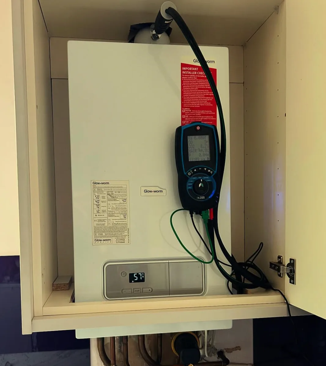 Boiler being tested with a flue gas analyser during professional heating work