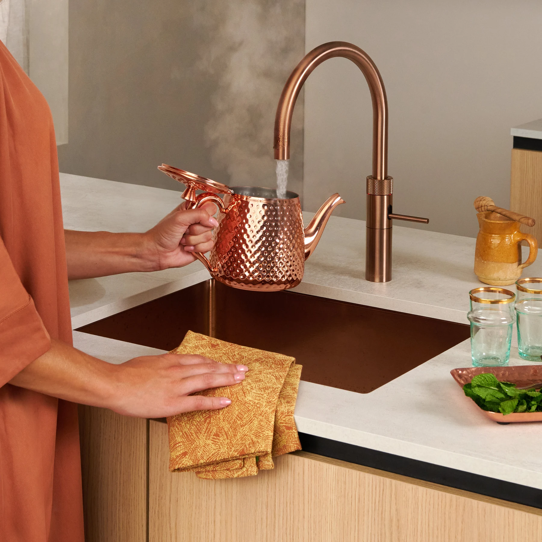 Boiling-water tap dispensing hot water in a modern kitchen